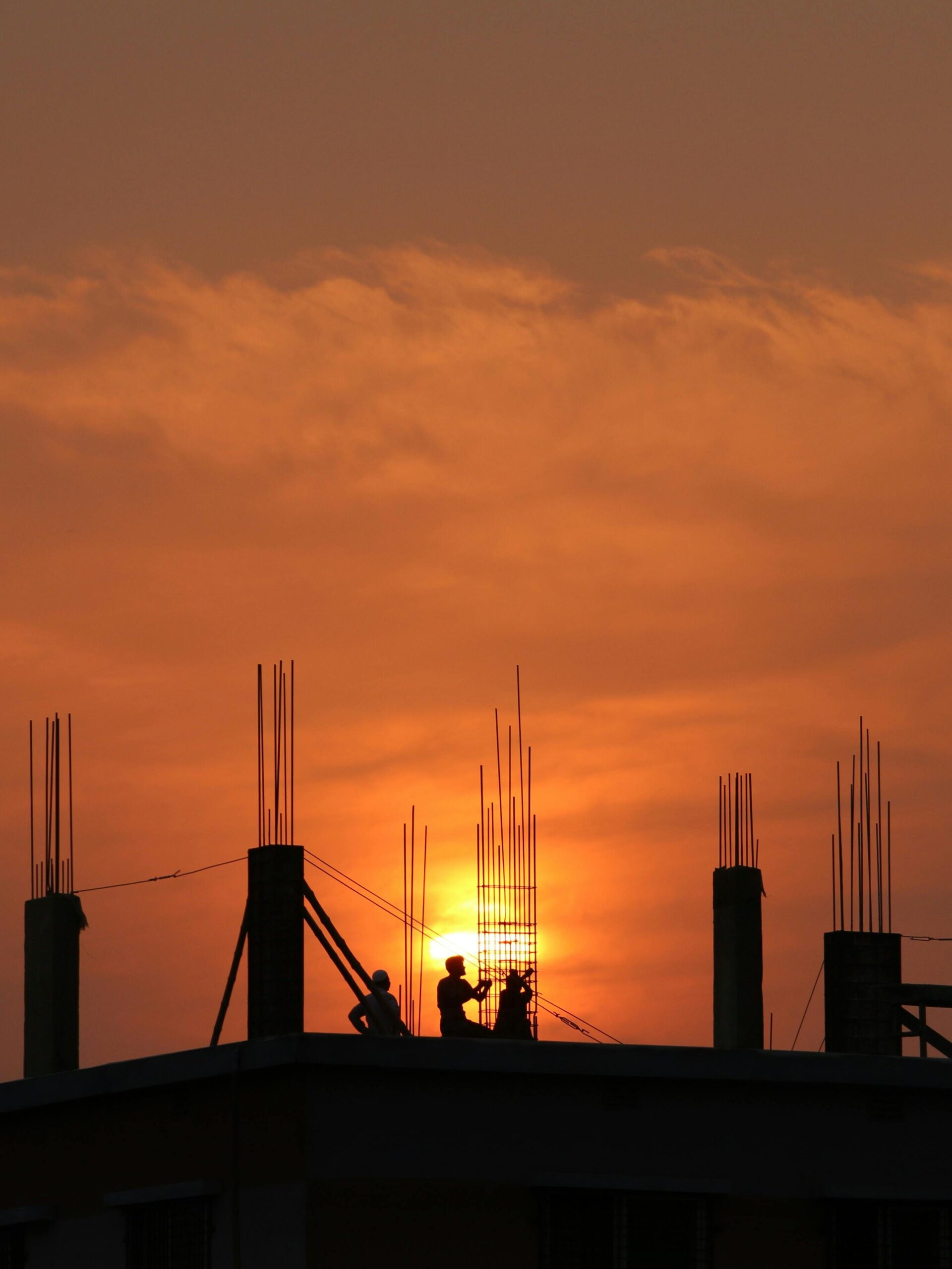 Silhouette of Men in Construction Site during Sunset